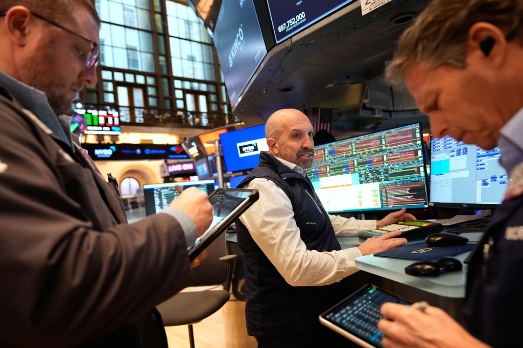 James Denaro, center, and others work on the floor at the New York Stock Exchange in New York, Monday, March 2, 2026. (AP Photo/Seth Wenig)