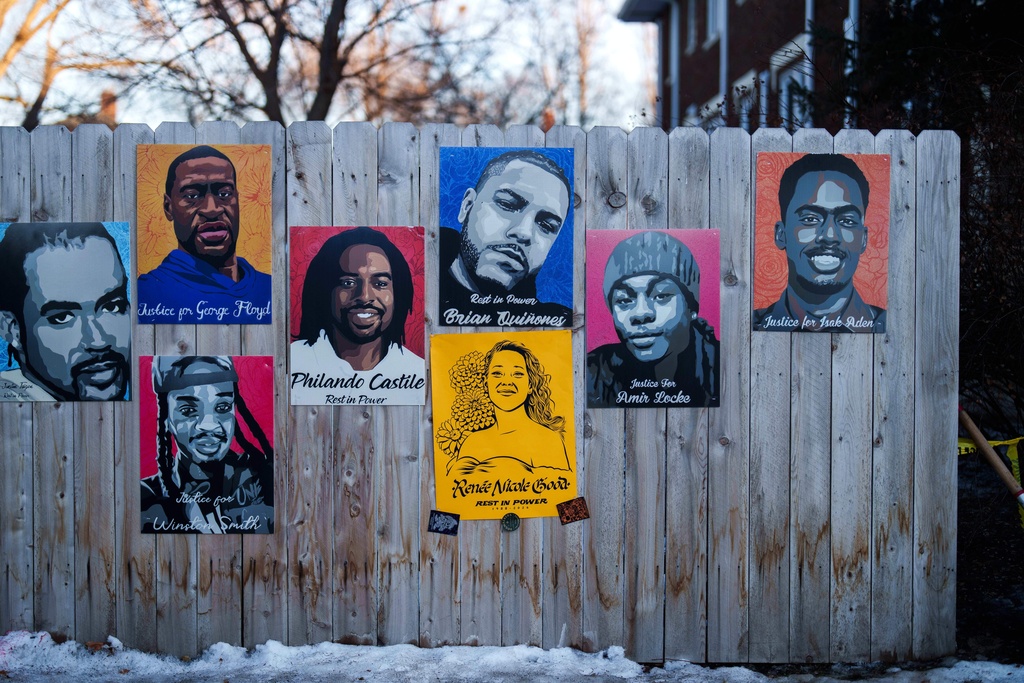 A poster depicting Renee Good, who was fatally shot by an ICE officer last week, is displayed on a fence alongside other people who were killed by police, in Minneapolis, Wednesday, Jan. 14, 2026. (AP Photo/Adam Gray)