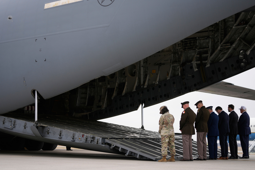 From right, President Donald Trump, Vice President JD Vance, Defense Secretary Pete Hegseth and Chairman of the Joint Chiefs of Staff Gen. Dan Caine say a prayer before a casualty return for the soldiers who were killed in a drone strike at a command center in Kuwait after the U.S. and Israel launched its military campaign against Iran, Saturday, March 7, 2026, at Dover Air Force Base, Del. (AP Photo/Mark Schiefelbein)