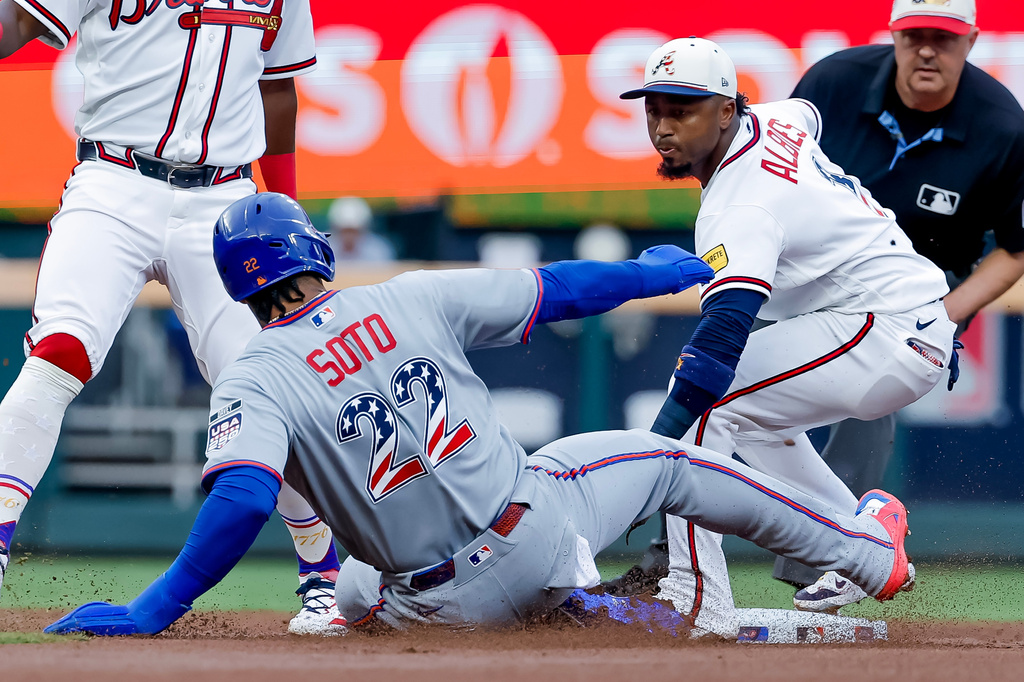 Atlanta Braves second baseman Ozzie Albies, front right, tags out New York Mets' Juan Soto (22) to complete a double play during the first inning of a baseball game, Saturday, July 4, 2026, in Atlanta. (AP Photo/Erik S. Lesser)