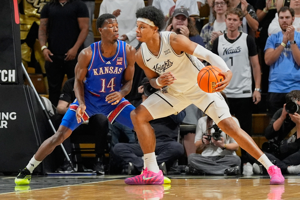 Central Florida forward Jamichael Stillwell, right, make a move to get past Kansas guard Melvin Council Jr. (14) during the first half of an NCAA college basketball game, Saturday, Jan. 3, 2026, in Orlando, Fla. (AP Photo/John Raoux)