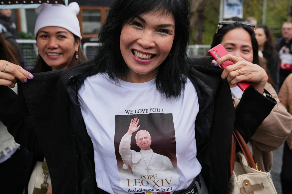 A woman shows her t-shirt as she arrives for a Mass led by Pope Leo XIV at the Volkswagen Arena venue, in Istanbul, Turkey, Saturday, Nov. 29, 2025. (AP Photo/Dilara Acikgoz)