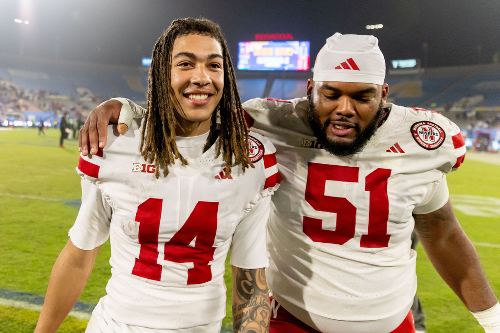 Nebraska quarterback TJ Lateef (14) and Nebraska offensive lineman Justin Evans (51) embrace after defeating UCLA at an NCAA college football game Saturday, Nov. 8, 2025, in Pasadena, Calif. (AP Photo/Ethan Swope)