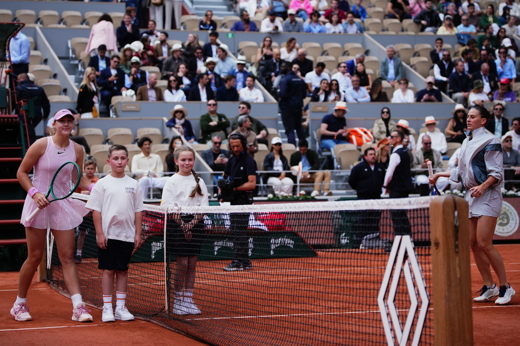 Russia's Mirra Andreeva poses with children while Ukraine's Marta Kostyuk refused to join before the semifinal tennis match at the French Open in Paris, Thursday, June 4, 2026. (AP Photo/Christophe Ena)