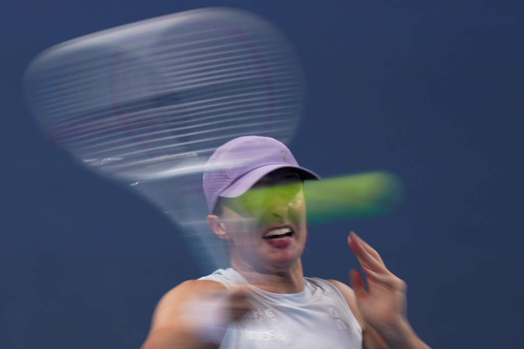 Iga Swiatek of Poland plays a forehand return to Emma Navarro, of the United States during the women's singles match for the China Open tennis tournament, in Beijing, China, Wednesday, Oct. 1, 2025. (AP Photo/Mahesh Kumar A.)
