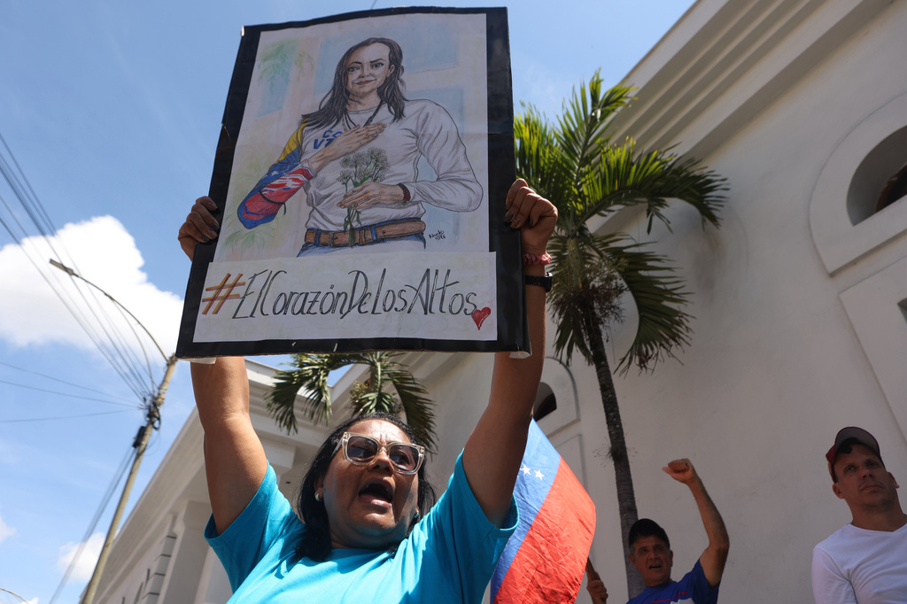 A supporter of opposition leader Maria Corina Machado holds up a poster with her image, during a rally calling for her return to the country and immediately elections in Los Teques, Venezuela, Sunday, Sept. 27, 2026. (AP Photo/Pedro Mattey)