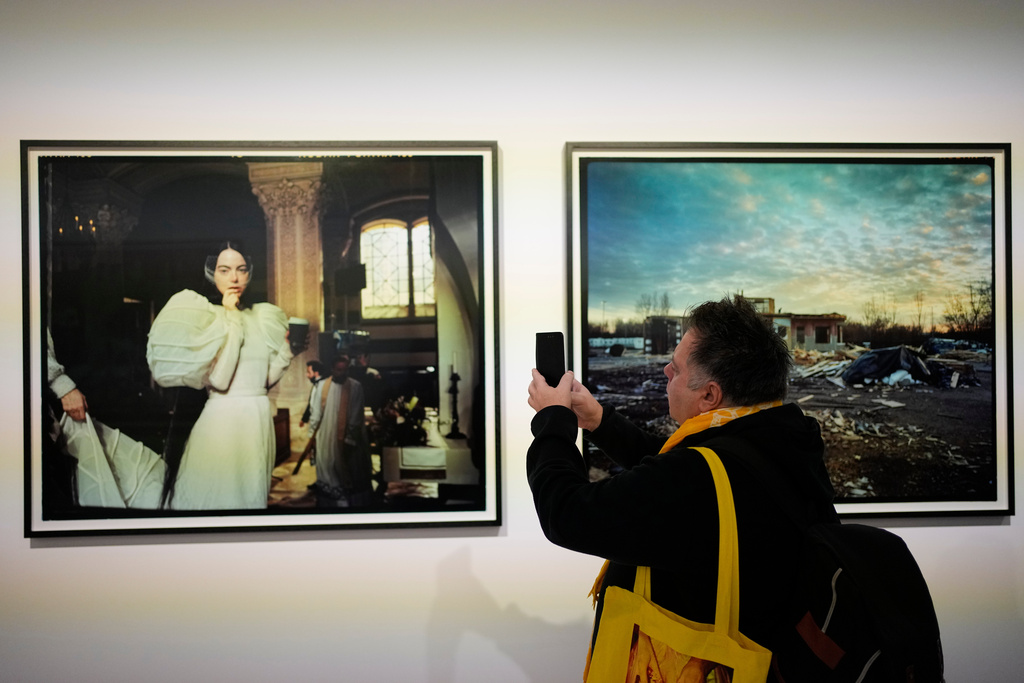A visitor takes a picture of a portrait of actress Emma Stone at an exhibition of images by Oscar nominated director Yorgos Lanthimos at Onassis Stegi in Athens, Greece, on Friday, March 6, 2026. (AP Photo/Thanassis Stavrakis)