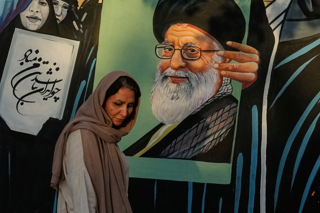 A woman walks past a mural depicting a portrait of the late Iranian Supreme Leader Ayatollah Ali Khamenei, who was killed in the U.S. and Israel strike on Feb. 28, in downtown Tehran, Iran, Saturday, July 18, 2026. (AP Photo/Vahid Salemi)