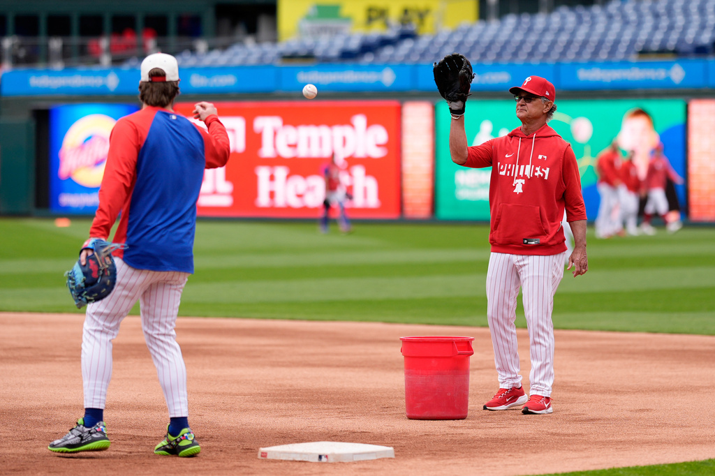 Philadelphia Phillies interim manager Don Mattingly, right, warms up with Bryce Harper before a baseball game against the San Francisco Giants Tuesday, April 28, 2026, in Philadelphia. (AP Photo/Matt Slocum)