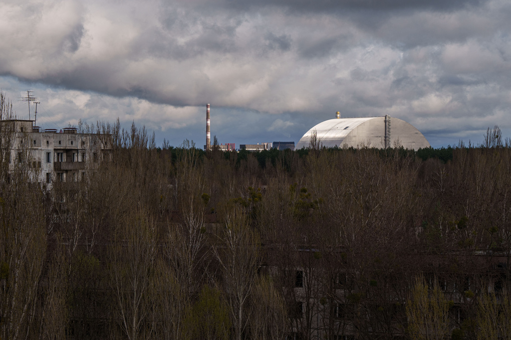 The Chernobyl nuclear power plant and the New Safe Confinement structure that was built to shield the damaged Reactor No. 4, is seen on Monday, April 6, 2026, from the abandoned town of Pripyat, Ukraine, where the workers at the plant once lived. (AP Photo/Evgeniy Maloletka)