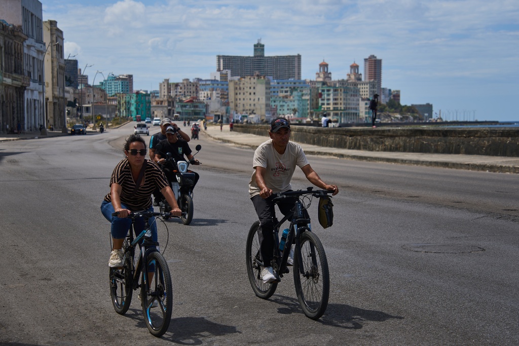 People ride their bicycles along the Malecón during a blackout in Havana, Cuba, Monday, March 16, 2026. (AP Photo/Ramon Espinosa)