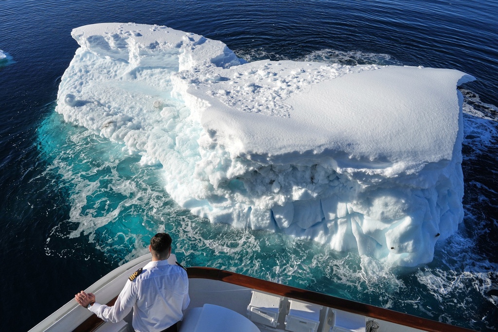 A member of the ship's crew looks at an iceberg near Yalour Islands in Antarctica, Monday, Nov. 24, 2025. (AP Photo/Mark Baker)