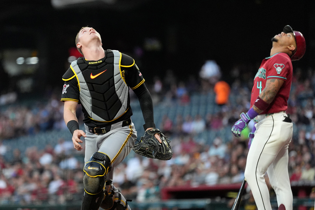 Pittsburgh Pirates catcher Henry Davis, left, looks for a foul ball hit by Arizona Diamondbacks' Ketel Marte (4) during the first inning of a baseball game, Wednesday, May 6, 2026, in Phoenix. (AP Photo/Ross D. Franklin)