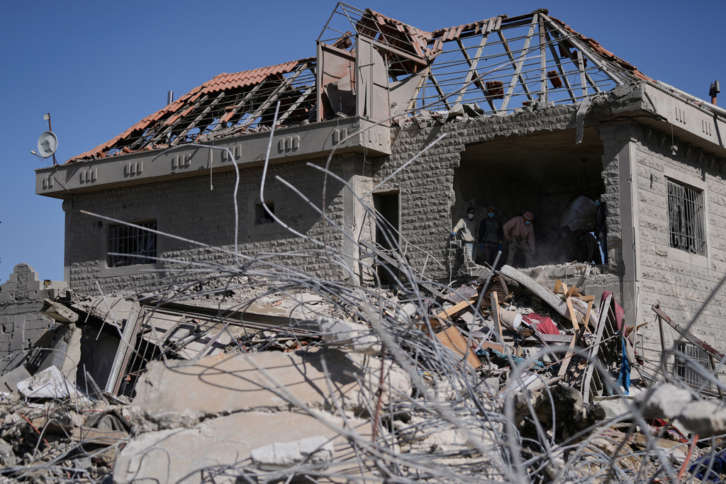 People collect the remains of their belongings from a building destroyed in an Israeli strike in the village of Bednayel in eastern Lebanon, Saturday, Feb. 21, 2026. (AP Photo/Bilal Hussein)