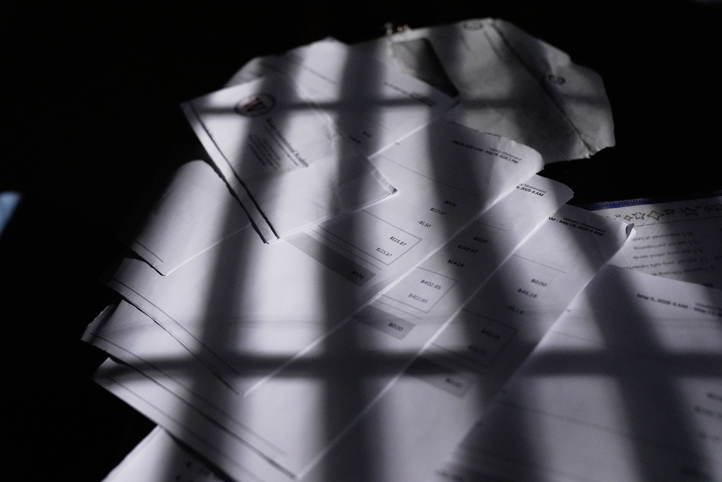 Bills and ride share payments lay on a kitchen table at Sechita McNair's home on June 7, 2025, in Jonesboro, Ga. (AP Photo/Brynn Anderson)