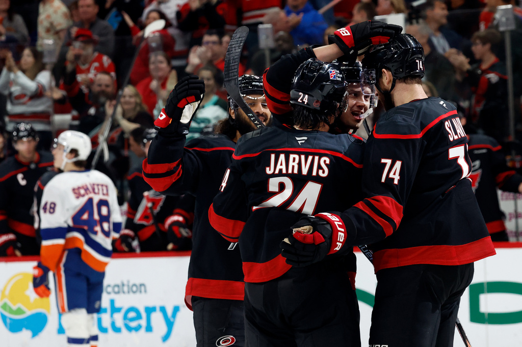 Carolina Hurricanes' Sebastian Aho, second right, celebrates his goal with teammates Jaccob Slavin, right, Seth Jarvis (24) and Jalen Chatfield, left, during the second period of an NHL hockey game against the New York Islanders in Raleigh, N.C., Saturday, April 4, 2026. (AP Photo/Karl DeBlaker)