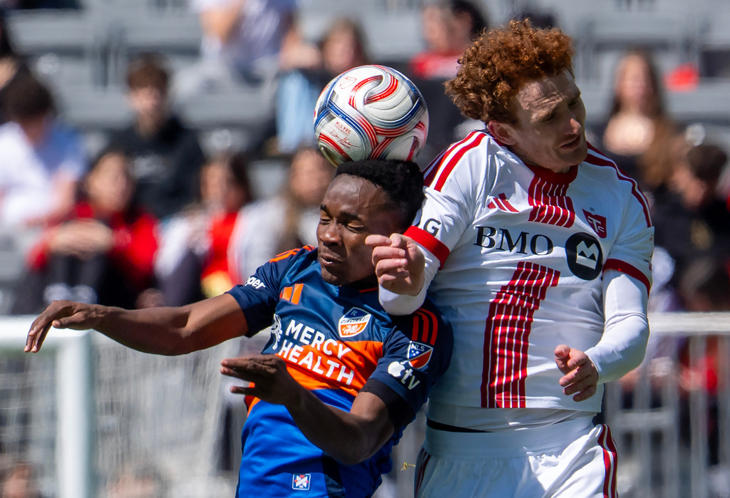FC Cincinnati midfielder Samuel Gidi, left, and Toronto FC forward Josh Sargent (9) battle for a head ball during the first half of an MLS soccer game in Toronto, Saturday, April 11, 2026. (Frank Gunn/The Canadian Press via AP)
