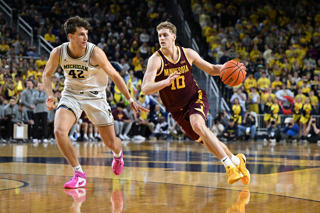 Minnesota forward Cade Tyson (10) drives past Michigan forward Will Tschetter (42) in the first half of an NCAA college basketball game in Ann Arbor, Mich., Tuesday, Feb. 24, 2026. (AP Photo/Lon Horwedel)