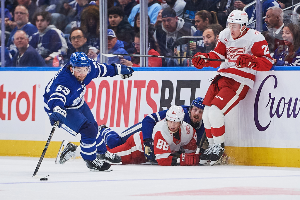 Toronto Maple Leafs' Matias Maccelli (63) scrambles for the puck as teammate Simon Benoit (2) hooks Detroit Red Wings' Patrick Kane (88) during second-period NHL hockey game action in Toronto, Monday, Oct. 13, 2025. (Sammy Kogan/The Canadian Press via AP)