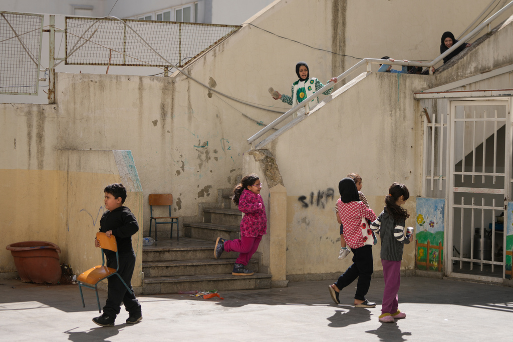 Children displaced by Israeli airstrikes in southern Lebanon and Dahiyeh, Beirut's southern suburbs, play in the courtyard of a school used as a shelter in Beirut, Lebanon, Monday, March 9, 2026. (AP Photo/Hassan Ammar)
