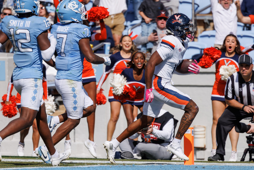 Virginia's Trell Harris (11) scores a touchdown ahead of North Carolina's Khmori House (7) and Greg Smith (12) during the first half of an NCAA college football game in Chapel Hill, N.C. Saturday, Oct. 25, 2025. (AP Photo/Ben McKeown) Virginia's Trell Harris (11) scores a touchdown ahead of North Carolina's Khmori House (7) and Greg Smith (12) during the first half of an NCAA college football game in Chapel Hill, N.C. Saturday, Oct. 25, 2025. (AP Photo/Ben McKeown)