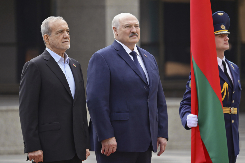 In this photo, released by Belarusian Presidential Press Service, Belarusian President Alexander Lukashenko, center, and Iranian President Masoud Pezeshkian, left, attend a welcome ceremony prior to their talks in Minsk, Belarus, Wednesday, Aug. 20, 2025. (Belarusian Presidential Press Service via AP)