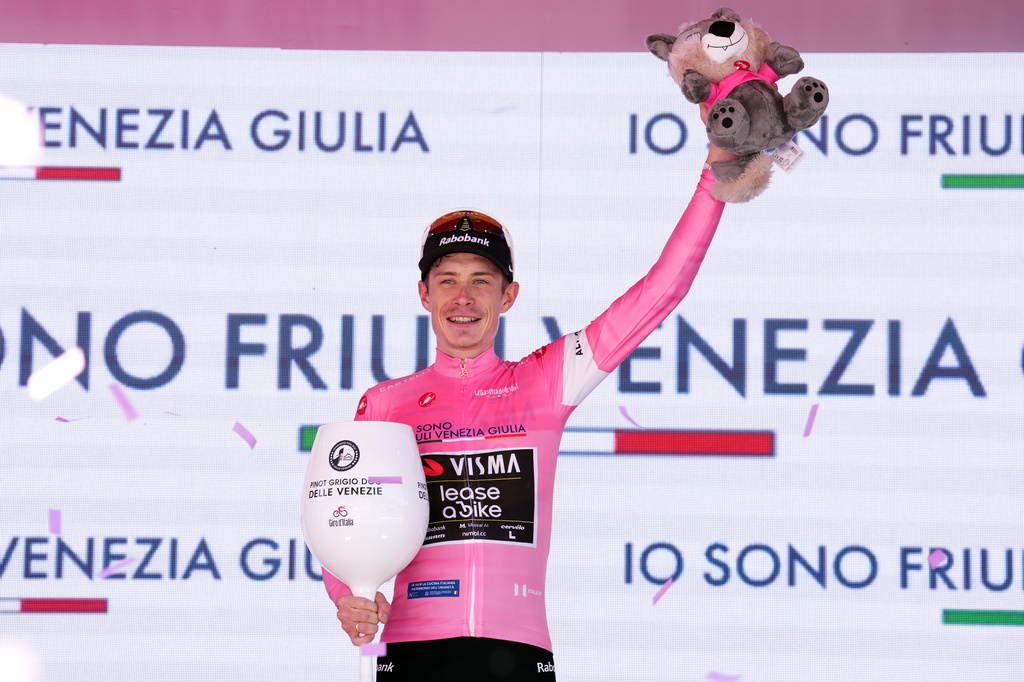 Denmark's Jonas Vingegaard wears the pink jersey of the race overall leader on the podium after winning the 14th stage of the Giro d'Italia cycling race, from Aosta to Pila, Italy, Saturday, May 23, 2026. (Gian Mattia d'Alberto /LaPresse via AP)