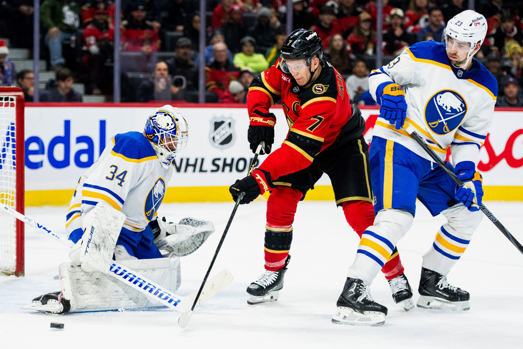 Ottawa Senators' Brady Tkachuk (7) misses a pass in front of Buffalo Sabres goaltender Alex Lyon (34) during second period NHL hockey action in Ottawa, Ontario, Tuesday, Dec. 23, 2025. (Spencer Colby/The Canadian Press via AP)