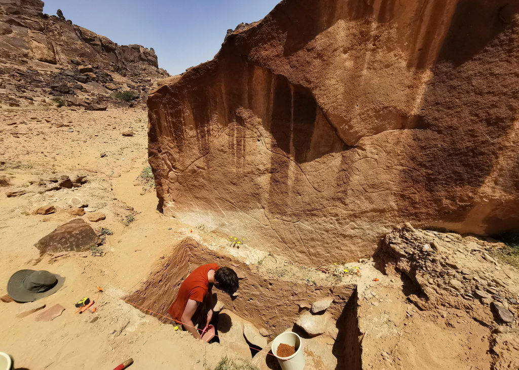 This image provided by Sahout Rock Art and Archaeology Project shows experts excavating the ground underneath an animal rock carving, in a desert in northern Saudi Arabia in 2023. (Maria Guagnin/Sahout Rock Art and Archaeology Project via AP)