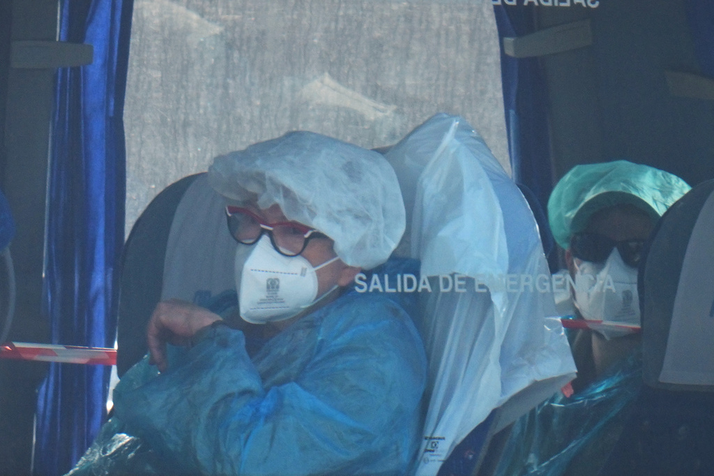 Passengers sit inside a bus after being disembarked from the hantavirus-stricken cruise ship MV Hondius at the port of Granadilla in Tenerife, Canary Islands, Spain, Sunday, May 10, 2026. (AP Photo/Manu Fernandez)