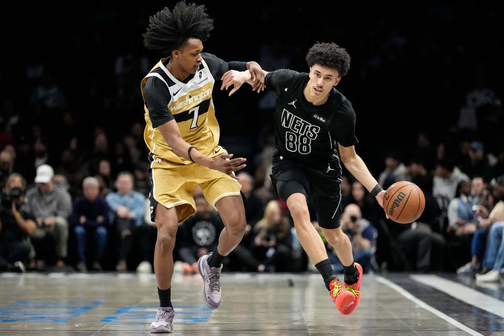 Brooklyn Nets guard Nolan Traore (88) drives past Washington Wizards guard Bub Carrington (7) during the first half of an NBA basketball game, Saturday, Feb. 7, 2026, in New York. (AP Photo/Yuki Iwamura)