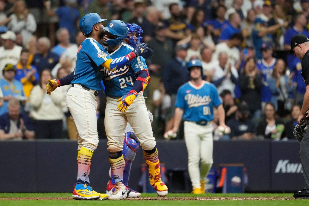 Milwaukee Brewers' William Contreras (24) hugs Milwaukee Brewers' Jackson Chourio, left, after hitting a two-run home run during the seventh inning of a baseball game against the Chicago Cubs, Friday, June 26, 2026, in Milwaukee. (AP Photo/Aaron Gash)