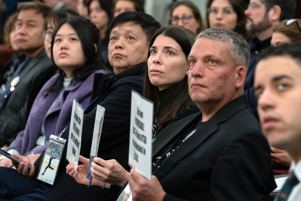 Family members of the people who were killed in the midair collision near Washington Reagan National Airport listen the National Transportation Safety Board (NTSB) Chairwoman Jennifer Homendy as she testifies before the Senate Committee on Commerce, Science, and Transportation hearing at Capitol Hill, Thursday, Feb. 12, 2026, in Washington. (AP Photo/Jose Luis Magana)