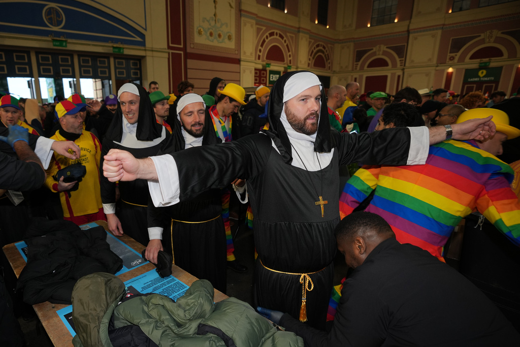 Darts fans in costume arrive to watch the World Darts Championships at Alexandra Palace in London, Monday, Dec. 15, 2025. (AP Photo/Kin Cheung)
