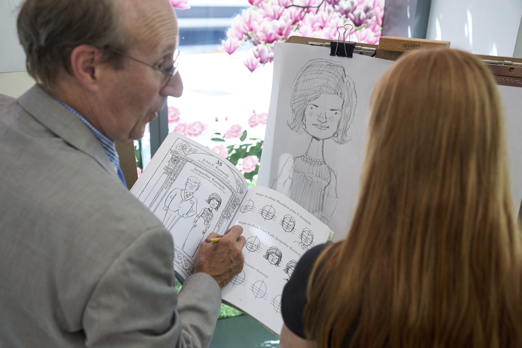 John Hutton, illustrator and professor of art history at Salem College, shows Adelaide Baldus, 16, of La Plata, Md., how to draw a picture of first lady Jacqueline Kennedy, Tuesday, Aug. 12, 2025, from his book, "How To Draw The Presidents and First Ladies," at The People's House, a museum in Washington. (AP Photo/Jacquelyn Martin)