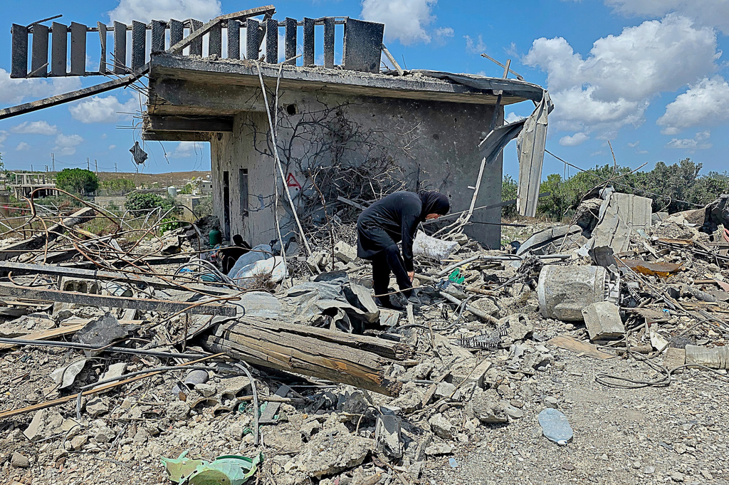 A Lebanese woman clears debris of her destroyed house in the village of Zawtar al-Gharbiyeh, southern Lebanon, Sunday, July 26, 2026. (AP Photo/Ahmad Mantash)