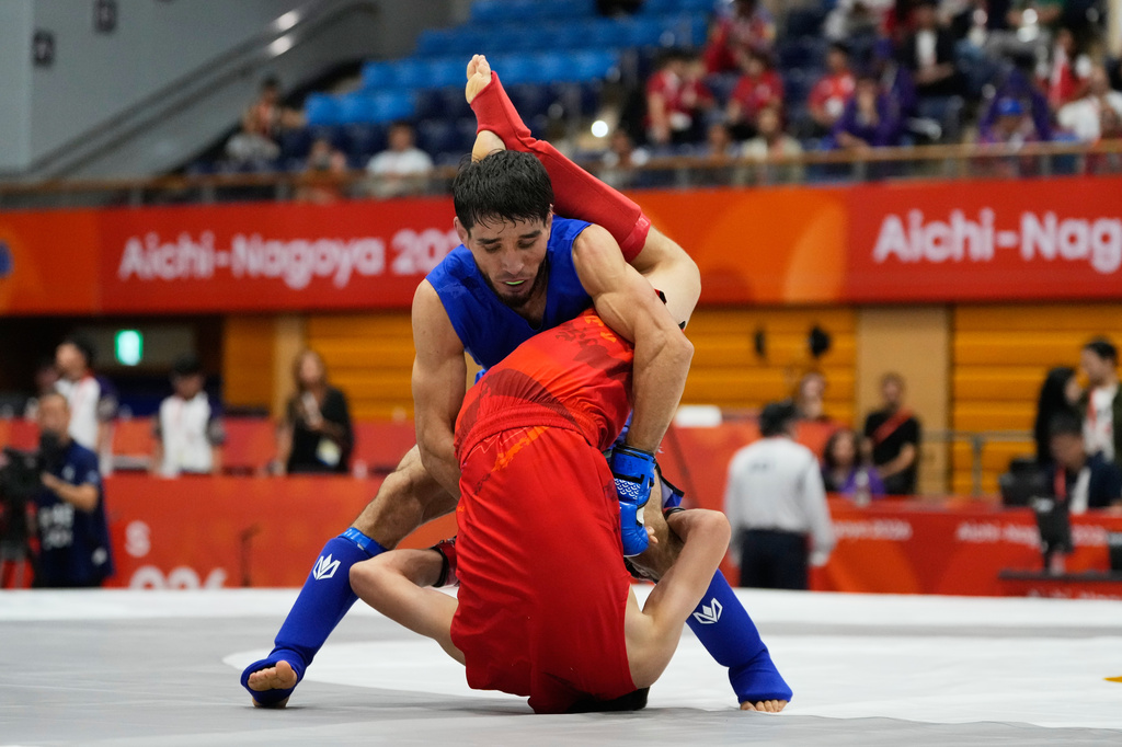 Firdaus Atamuratov of Uzbekistan, bottom, competes with Mirzobek Umarov of Tajikistan during their men's modern 60kg mixed martial arts final at the Asian Games in Nagoya, Japan, Tuesday, Sept. 22, 2026. (AP Photo/Dita Alangkara)