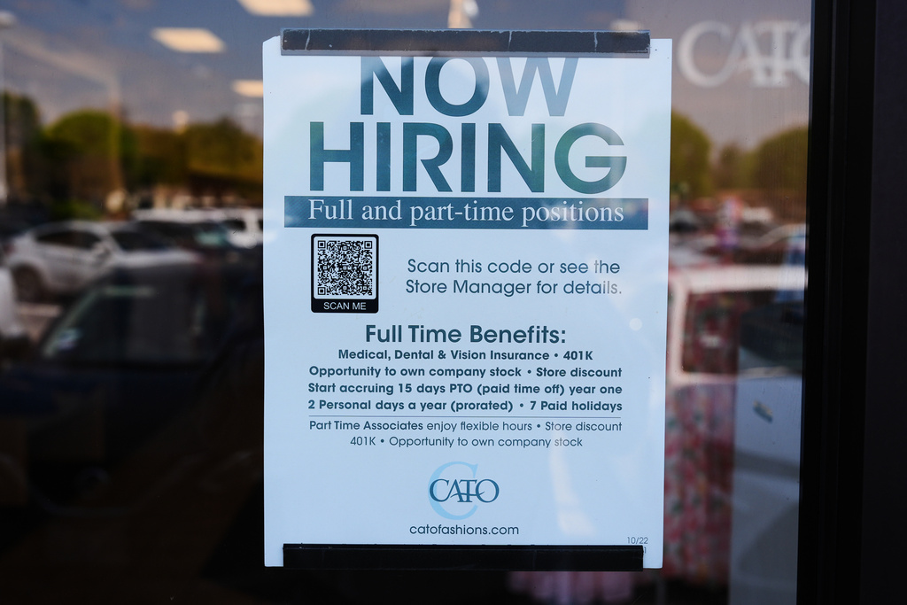A now hiring sign sits on the window of a retail clothing store in Garland, Texas, Monday, March 23, 2026. (AP Photo/LM Otero)