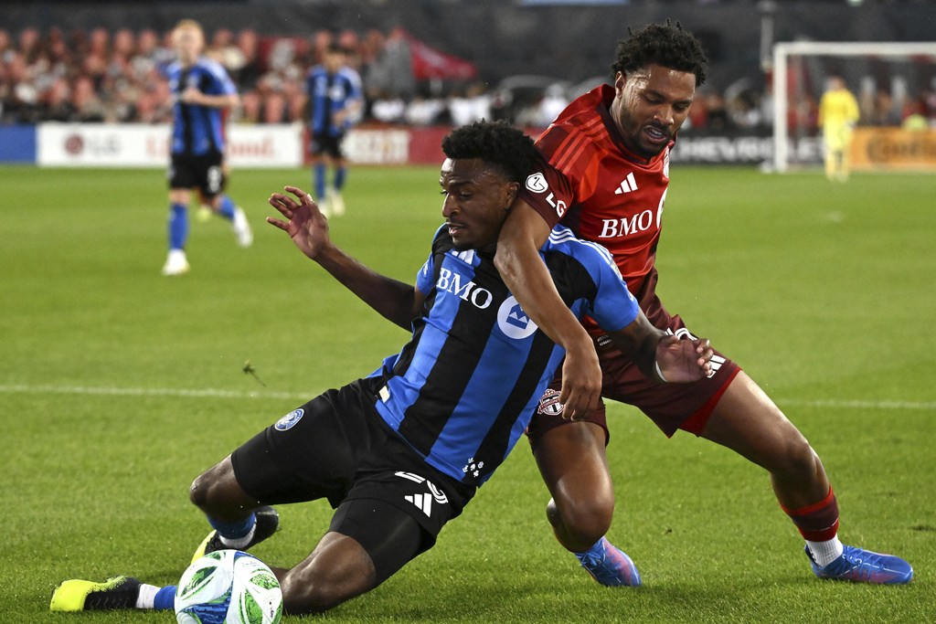 Toronto FC's Kosi Thompson, right, tackles CF Montreal's Dante Sealy (25) during first half MLS soccer action in Toronto on Saturday, August 30, 2025. (Jon Blacker/The Canadian Press via AP)