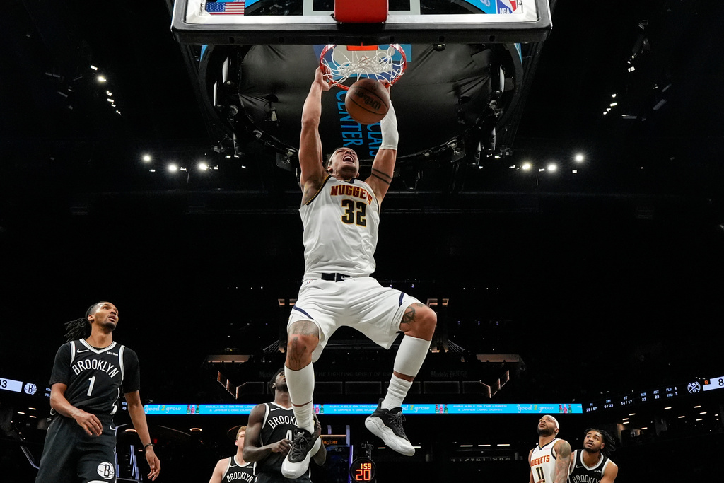 Denver Nuggets forward Aaron Gordon (32) hangs from the rim after dunking during the second half of an NBA basketball game against the Brooklyn Nets, Sunday, Jan. 4, 2026, in New York. (AP Photo/Yuki Iwamura)