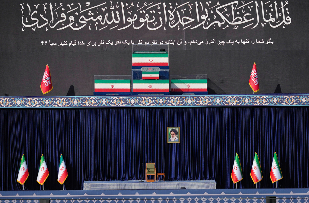 The coffins of the late Iranian Supreme Leader Ayatollah Ali Khamenei and members of his family are displayed on a platform above an empty chair at the start of the dayslong funeral ceremonies at the Imam Khomeini Mosalla Grand Mosque in Tehran, Iran, Saturday, July 4, 2026. (AP Photo/Altaf Qadri)
