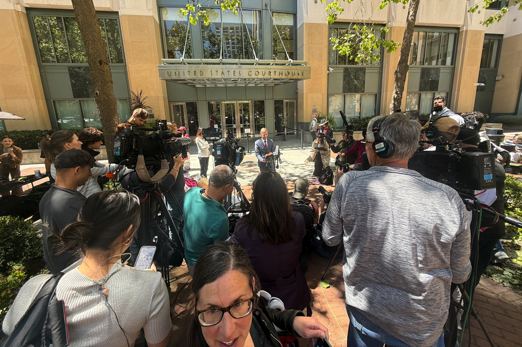 Marc Toberoff, attorney for Elon Musk, is surrounded by media outside the U.S. District Court Monday, May 18, 2026, in Oakland, Calif. (AP Photo/Nathan Weyland)