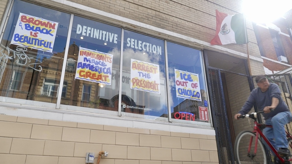 A bicyclist passes Definitive Selection clothing store, one of many businesses in the predominantly Latino neighborhood that has seen a slowdown in foot traffic since President Donald Trump's threats of a federal law enforcement intervention, on Friday, Sept. 5, 2025 in Chicago. (AP Photo/Mark Vancleave)