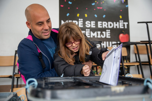 A man holds his daughter to cast his ballot on Sunday's municipal elections in capital Pristina, Kosovo on Sunday, Oct 12, 2025. About 2.1 million registered voters are choosing mayors in 38 municipalities. (AP Photo/Visar Kryeziu) A man holds his daughter to cast his ballot on Sunday's municipal elections in capital Pristina, Kosovo on Sunday, Oct 12, 2025. About 2.1 million registered voters are choosing mayors in 38 municipalities. (AP Photo/Visar Kryeziu)