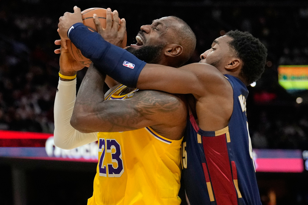 Los Angeles Lakers forward LeBron James (23) is fouled by Cleveland Cavaliers guard Donovan Mitchell, right, in the second half of an NBA basketball game in Cleveland, Wednesday, Jan. 28, 2026. (AP Photo/Sue Ogrocki)