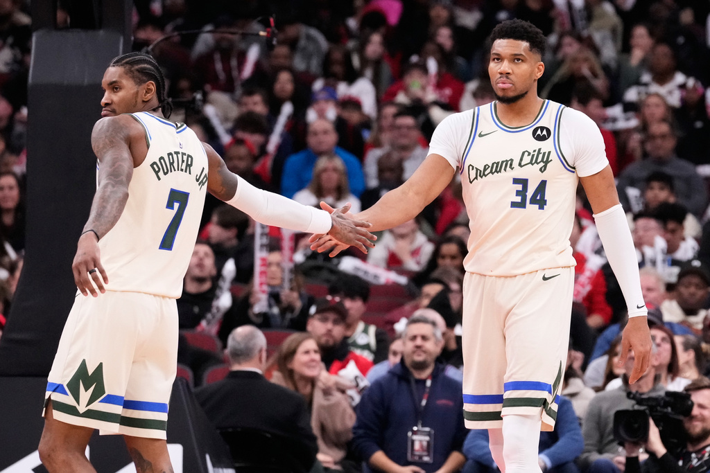 Milwaukee Bucks forward Giannis Antetokounmpo, right, celebrates with guard Kevin Porter Jr.. left, during the second half of an NBA basketball game against the Chicago Bulls in Chicago, Saturday, Dec. 27, 2025. (AP Photo/Nam Y. Huh)