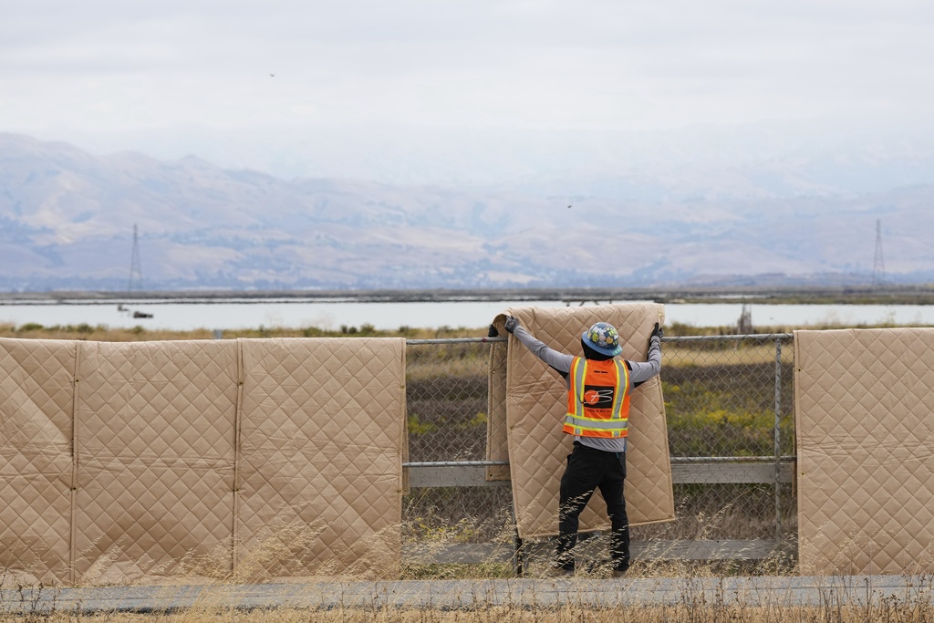 Crew members install sound blankets to protect wildlife at the Pond A2W site of the South Bay Salt Pond Restoration Project, Thursday, July 24, 2025, in Mountain View, Calif. (AP Photo/Godofredo A. Vásquez)