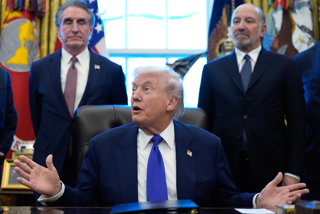 President Donald Trump speaks in the Oval Office of the White House, Monday, Feb. 2, 2026, in Washington, as Interior Secretary Doug Burgum and Commerce Secretary Howard Lutnick, right, listen. (AP Photo/Alex Brandon)