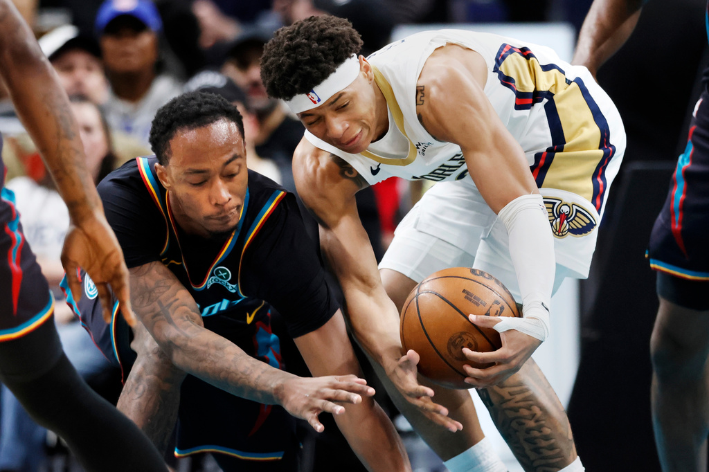 Detroit Pistons forward Ronald Holland II, left, and New Orleans Pelicans guard Jeremiah Fears, right, scramble for a loose ball during the first half of an NBA basketball game Thursday, March 26, 2026, in Detroit. (AP Photo/Duane Burleson)
