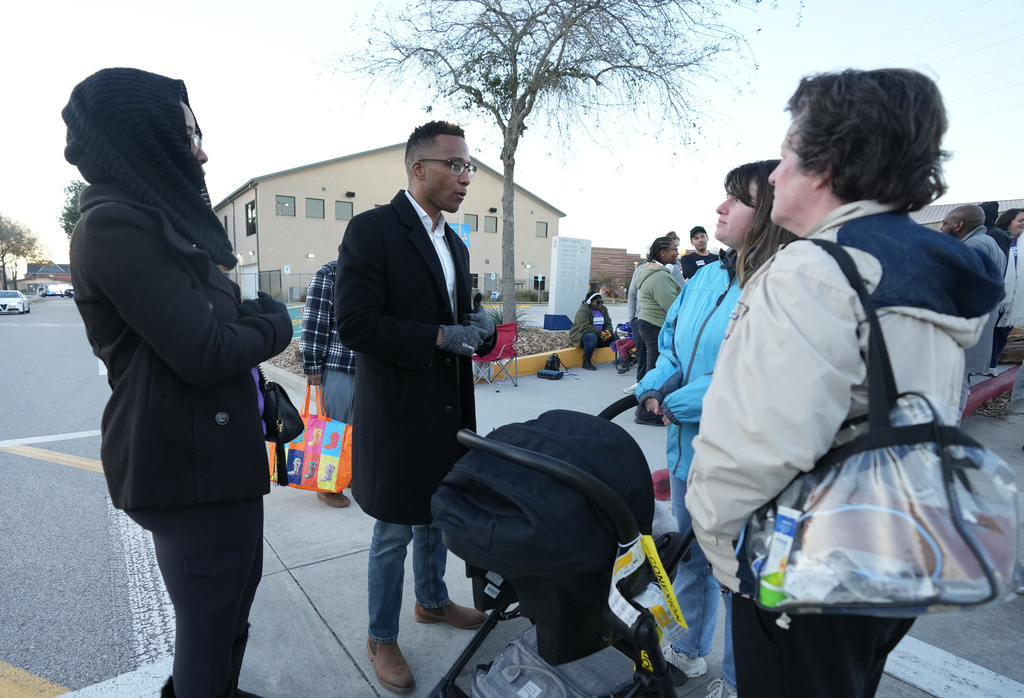 Texas Congressional Candidate Christian Menefee talks with voters as he visited a polling location at Wheeler Avenue Baptist Church on Election Day, in Houston, Saturday, Jan. 31, 2026. (AP Photo/Karen Warren)